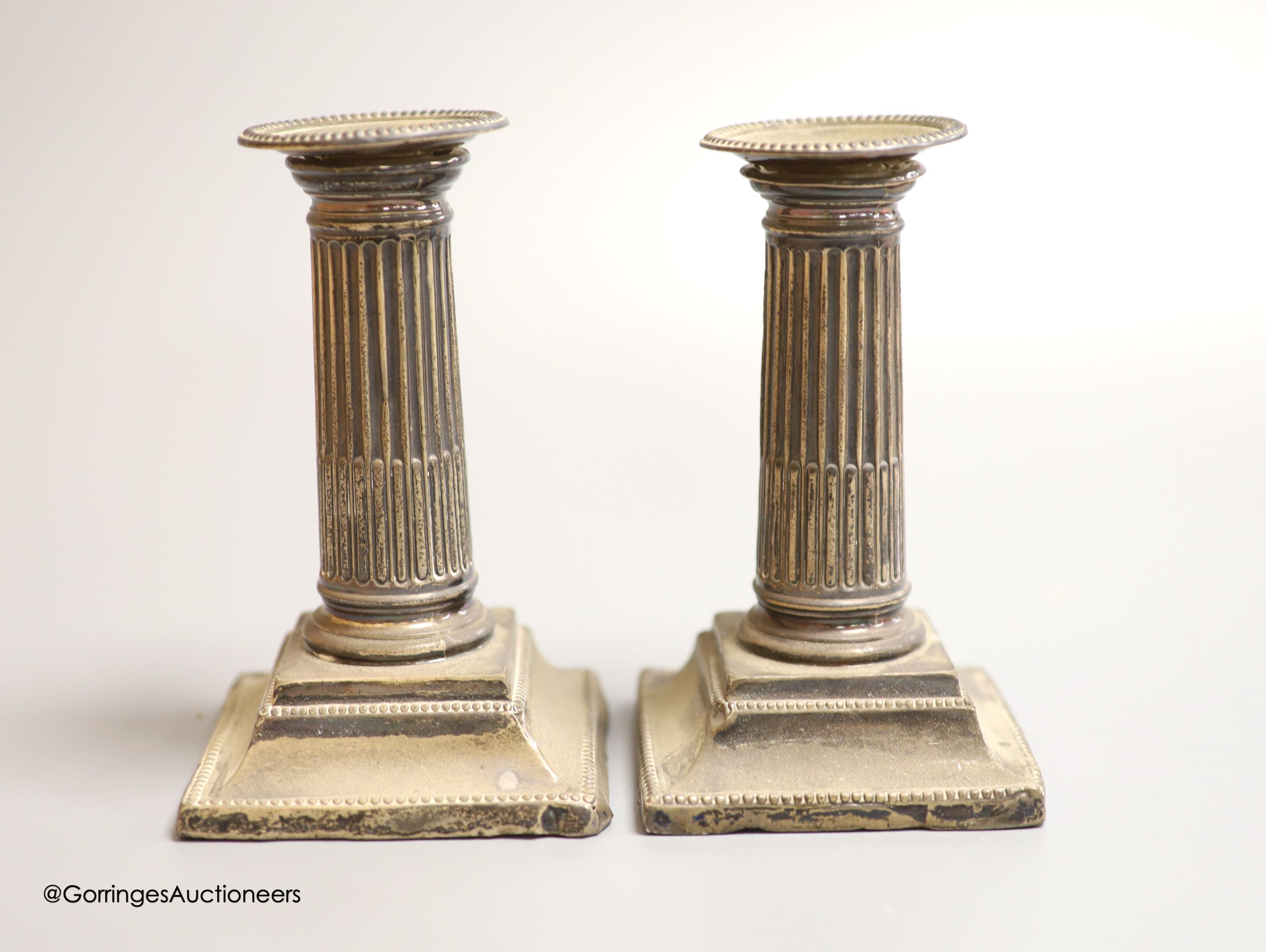 A pair of Edwardian silver mounted dwarf candlesticks, James Deakin & Sons, Sheffield, 1908, height 13.2cm, weighted (a.f.).